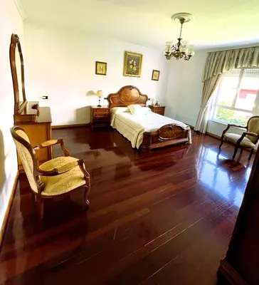 a bedroom with a bed and a table and chairs at EnVIVEIRO Villa Bonita in Viveiro