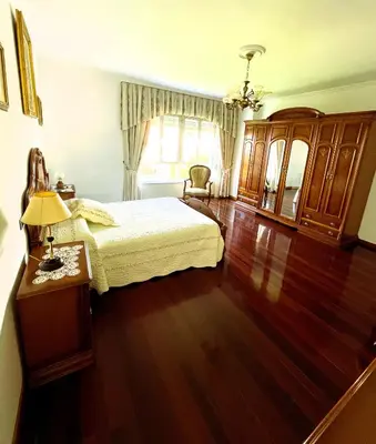 a bedroom with a bed and a wooden floor at EnVIVEIRO Villa Bonita in Viveiro
