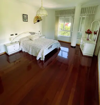 a bedroom with a bed and a wooden floor at EnVIVEIRO Villa Bonita in Viveiro
