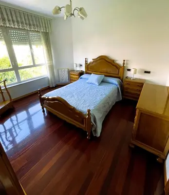 a bedroom with a bed and a wooden floor at EnVIVEIRO Villa Bonita in Viveiro
