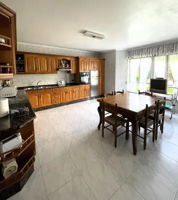 a kitchen with a wooden table and a dining room at EnVIVEIRO Villa Bonita in Viveiro