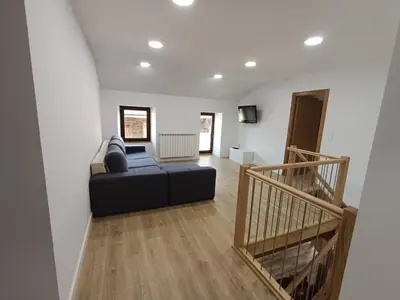 a living room with a black couch and a staircase at Casa Do Castelo in Lugo