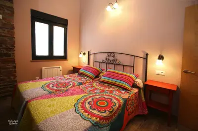a bedroom with a bed with a colorful blanket and pillows at Apartamentos Bouso in Villaframil