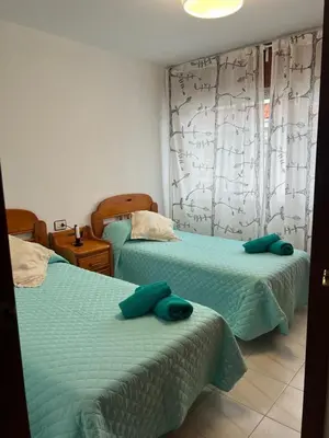 a bedroom with two beds with green sheets at Miño Center Home in Miño