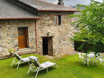 a group of chairs and tables in front of a building at La casa de atrás in Arancedo