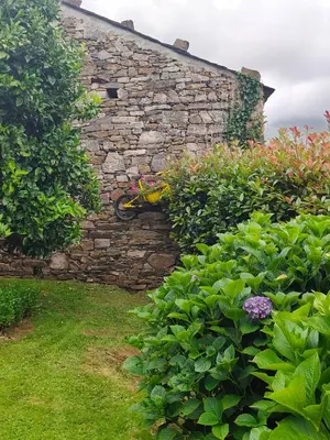 a bicycle is leaning against a stone wall at La casa de atrás in Arancedo