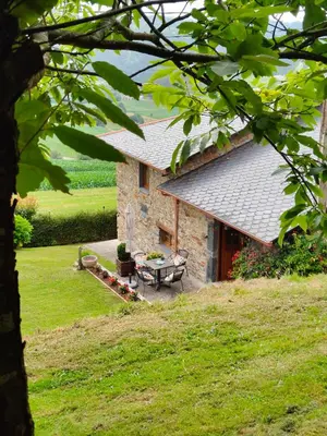 a stone house with a table in front of it at La casa de atrás in Arancedo