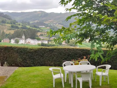 a white table and chairs in the grass at La casa de atrás in Arancedo