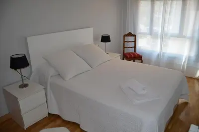 a bedroom with a white bed and a red chair at Orballo Alaricano in Allariz