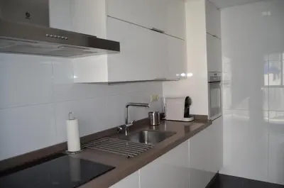 a white kitchen with a sink and a stove at Orballo Alaricano in Allariz