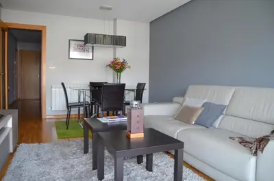 a living room with a white couch and a table at Orballo Alaricano in Allariz