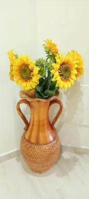 a vase filled with yellow sunflowers sitting on a table at Apartamento PLAYAS Y SIRENAS SAN CIPRIÁN in San Ciprián