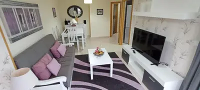 a living room with a couch and a tv at Apartamento PLAYAS Y SIRENAS SAN CIPRIÁN in San Ciprián