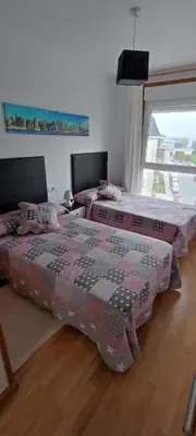 two beds sitting next to each other in a room at Apartamento PLAYAS Y SIRENAS SAN CIPRIÁN in San Ciprián
