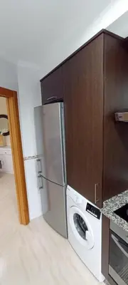a kitchen with a refrigerator and a washing machine at Apartamento PLAYAS Y SIRENAS SAN CIPRIÁN in San Ciprián