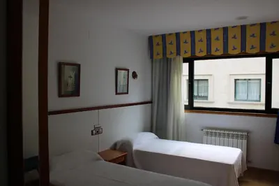 a bedroom with two beds and a window at Hotel Villa de Ares in Ares