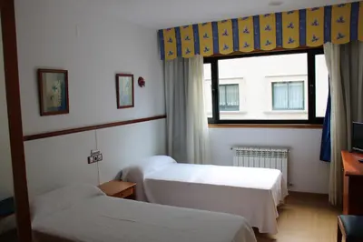 a hotel room with two beds and a window at Hotel Villa de Ares in Ares