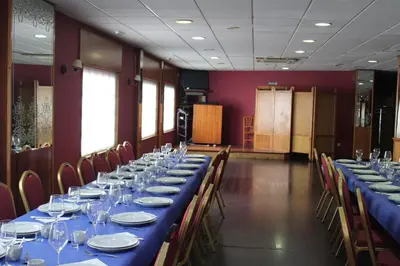 a dining room with a long blue table and chairs at Hotel Villa de Ares in Ares