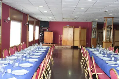 a long table in a room with red chairs and blue tables at Hotel Villa de Ares in Ares