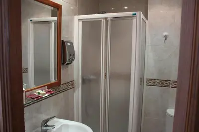 a bathroom with a shower and a sink and a mirror at Hotel Villa de Ares in Ares