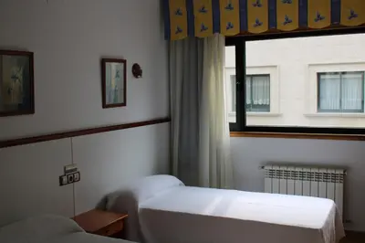 a bedroom with two beds and a window at Hotel Villa de Ares in Ares