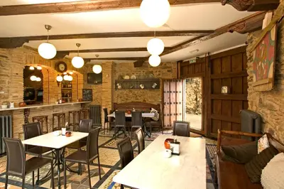 a restaurant with tables and chairs and a bar at Hostería Camino in Luyego de Somoza
