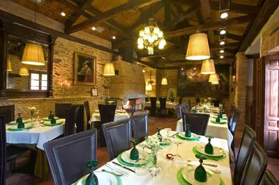 a restaurant with tables and chairs and a chandelier at Hostería Camino in Luyego de Somoza