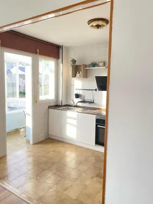 a kitchen with white cabinets and a stove top oven at Apartmento O Río in Burela de Cabo