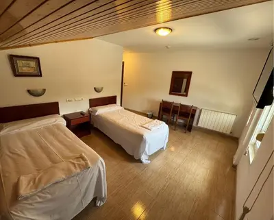 a room with two beds and a table and chairs at Hotel Luso Leixoes-Exclusivo para Empresas in Bergondo