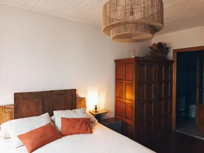 a bedroom with a bed and a chandelier at As casiñas da mina