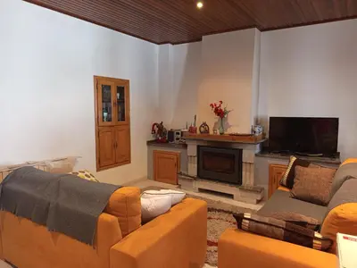 a living room with a couch and a television at As casiñas da mina