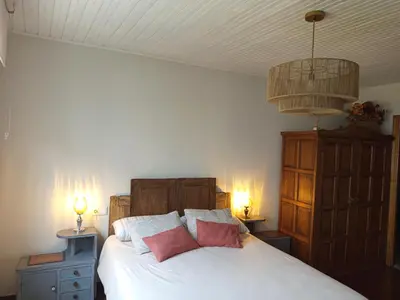 a bedroom with a white bed with two pink pillows at As casiñas da mina