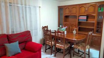 a dining room with a table and a red couch at playa de covas-Viveiro apartment in Viveiro