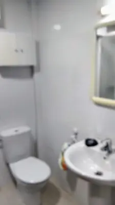 a white bathroom with a toilet and a sink at playa de covas-Viveiro apartment in Viveiro