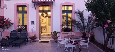 a patio with chairs and a table in front of a building at Casa Matilda - Encanto vintage con patio privado en el corazón de la Ribeira Sacra in Monforte de Lemos