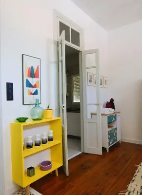 a room with a yellow shelf and a mirror at Casa Matilda - Encanto vintage con patio privado en el corazón de la Ribeira Sacra in Monforte de Lemos