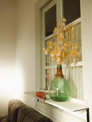 a glass vase sitting on a shelf next to a window at Casa Matilda - Encanto vintage con patio privado en el corazón de la Ribeira Sacra in Monforte de Lemos