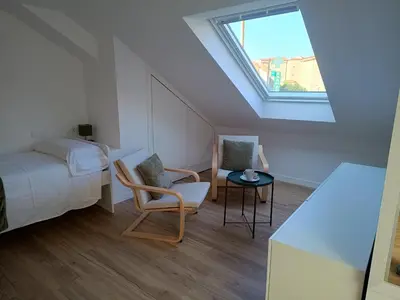 a bedroom with a bed and a table and a window at Roi Roots in Santiago de Compostela