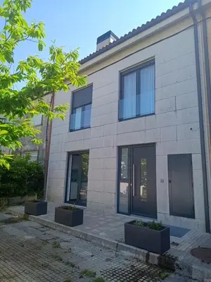a white brick building with black windows at Roi Roots in Santiago de Compostela