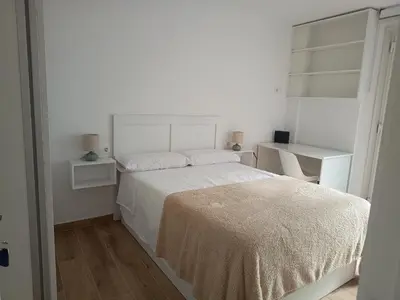 a white bedroom with a bed and a desk at Roi Roots in Santiago de Compostela