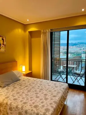 a bedroom with a bed and a view of a balcony at Vistas Miño II in Ourense