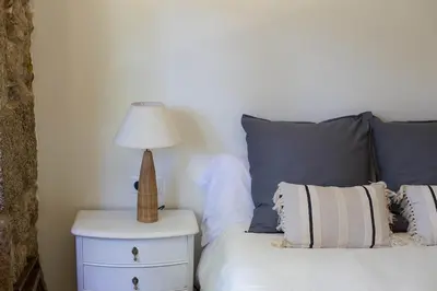 a bed with a nightstand with a lamp on it at Casa do Vigairo, en plena Ribeira Sacra