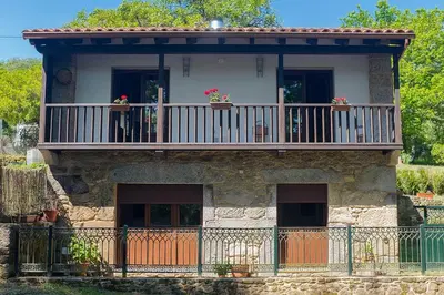 a building with a balcony with flowers on it at Casa do Vigairo, en plena Ribeira Sacra