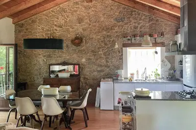 a kitchen with a table and chairs in a room at Casa do Vigairo, en plena Ribeira Sacra