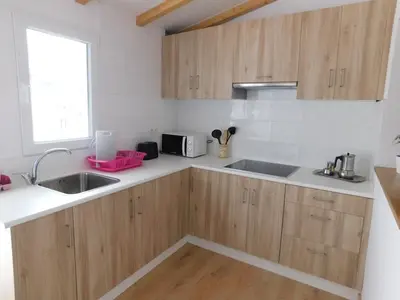 a kitchen with wooden cabinets and a sink and a window at Encantadora casa con unas magníficas vistas in Ribadeo