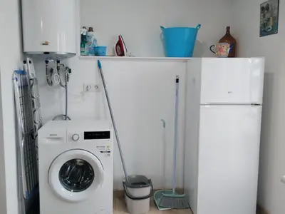 a laundry room with a washing machine and a refrigerator at Encantadora casa con unas magníficas vistas in Ribadeo