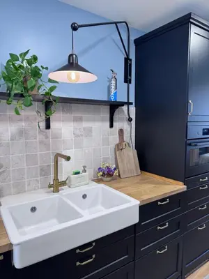 a kitchen with a white sink and a black cabinet at Casa Paz Lugo in Lugo