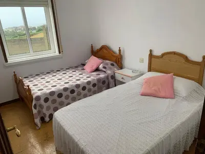 two beds in a room with a window at A Marosa playa in Burela de Cabo