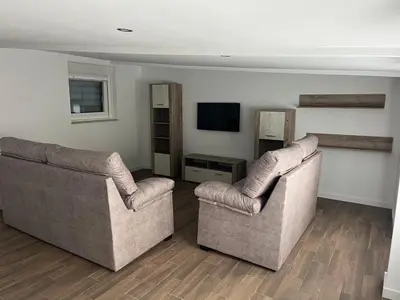 a living room with two chairs and a television at Casa da Morena in Foz