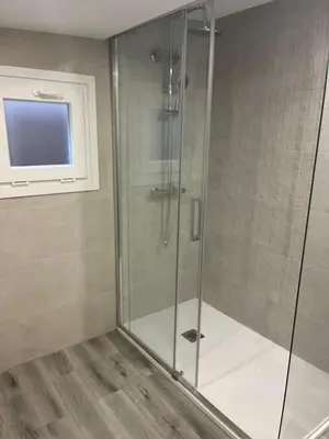 a glass shower in a bathroom with a window at Casa da Morena in Foz